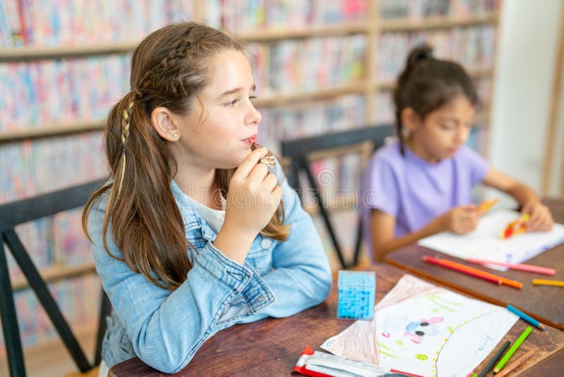 Caucasian Girl Enjoy With Eating Chocolate Or Candy During Art Subject Or Class While Her Friend Caucasian Girl Enjoy With Eating Chocolate Or Candy During Art Subject Or Class While Her Friend