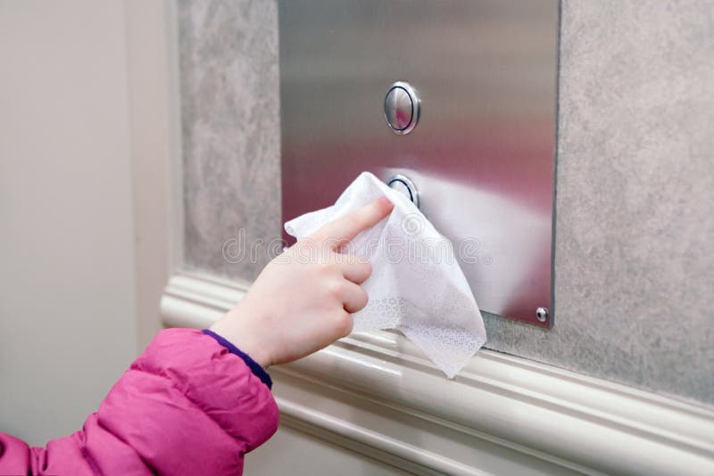 Caucasian girl pushing elevator button with disinfecting wet wipe. Precaution against virus spread. COVID-19 coronavirus danger and fast epidemic virus contagion concept. Caucasian girl pushing elevator button with disinfecting wet wipe. Precaution against virus spread. COVID-19 coronavirus danger and fast epidemic virus contagion concept