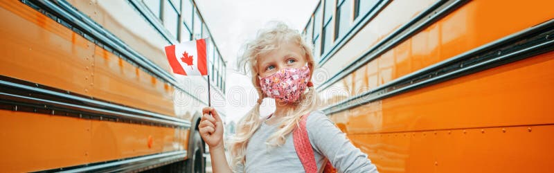 Caucasian girl student with face mask holding a Canadian flag. Student kid near yellow school bus in Canada. Education and back to royalty free stock photo Caucasian girl student with face mask holding a Canadian flag. Student kid near yellow school bus in Canada. Education and back to royalty free stock photo