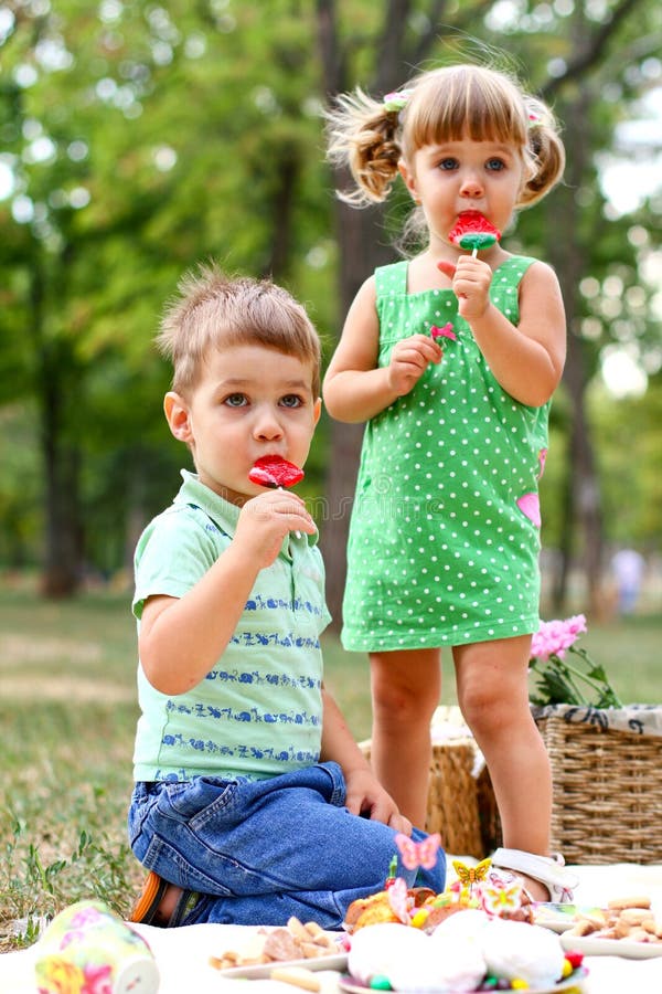 Caucasian little boy and girl eating sweets