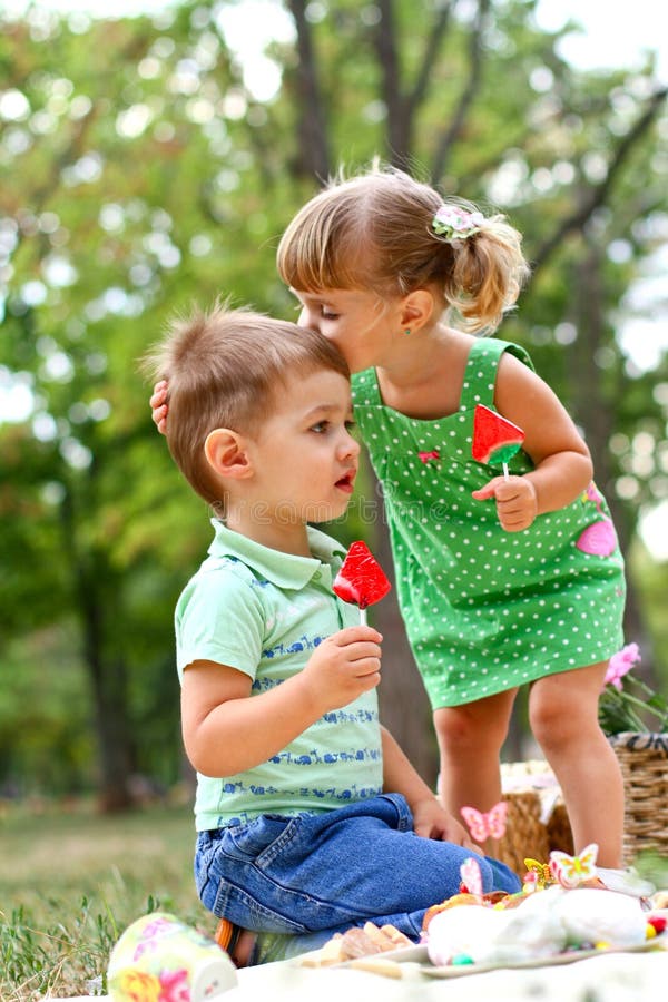 Caucasian little boy and girl eating sweets