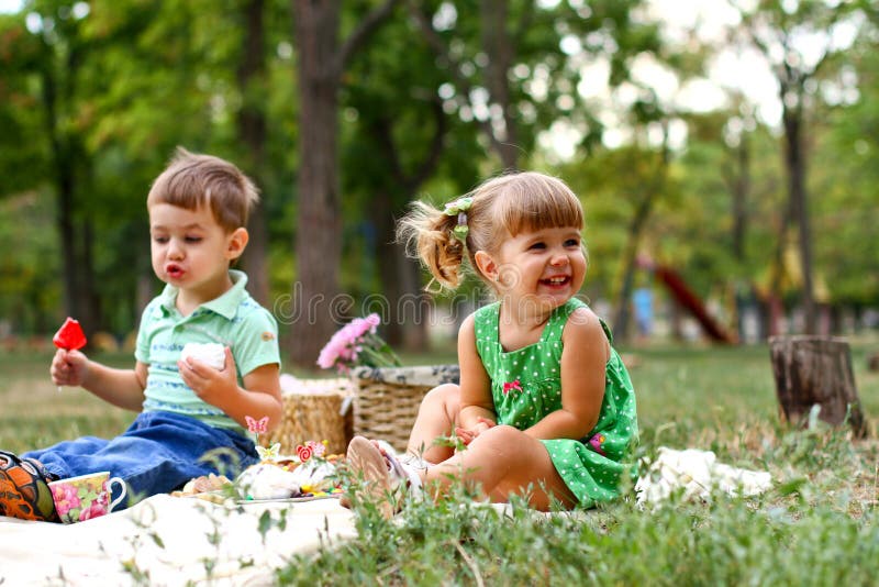 Caucasian little boy and girl eating sweets