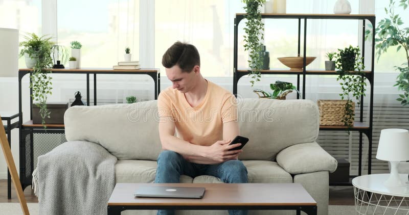 Bărbat caucazian care se simte dezgustat prin telefon acasă stock video