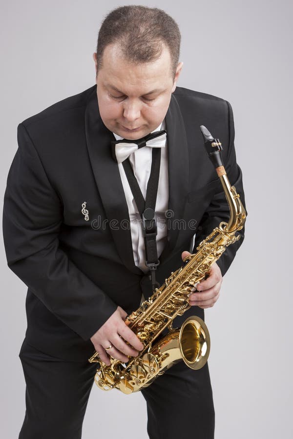Caucasian Man in Suite with Saxophone. Posing Against White Stock Photo