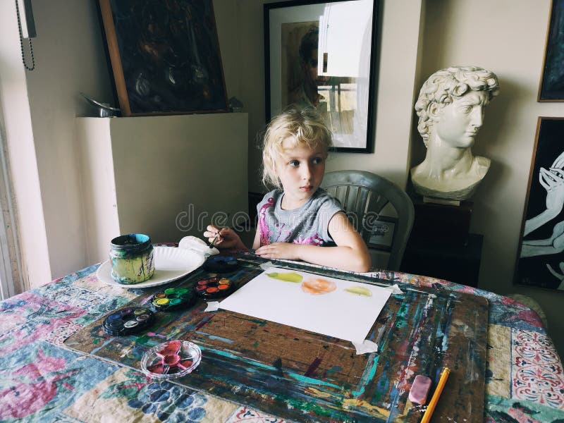 Caucasian preschooler girl sitting in art studio concentrated on painting fruits with brushes and water color paints stock photo Caucasian preschooler girl sitting in art studio concentrated on painting fruits with brushes and water color paints stock photo