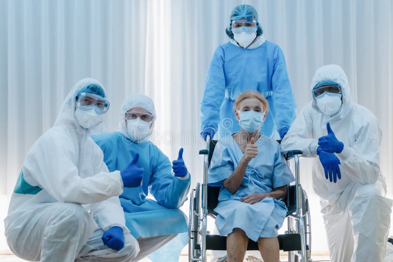 Caucasian senior coronavirus covid-19 infected patient sitting on wheel chair with happy doctor and medical team ready to send her. Back home after treatment royalty free stock photography Caucasian senior coronavirus covid-19 infected patient sitting on wheel chair with happy doctor and medical team ready to send her. Back home after treatment royalty free stock photography