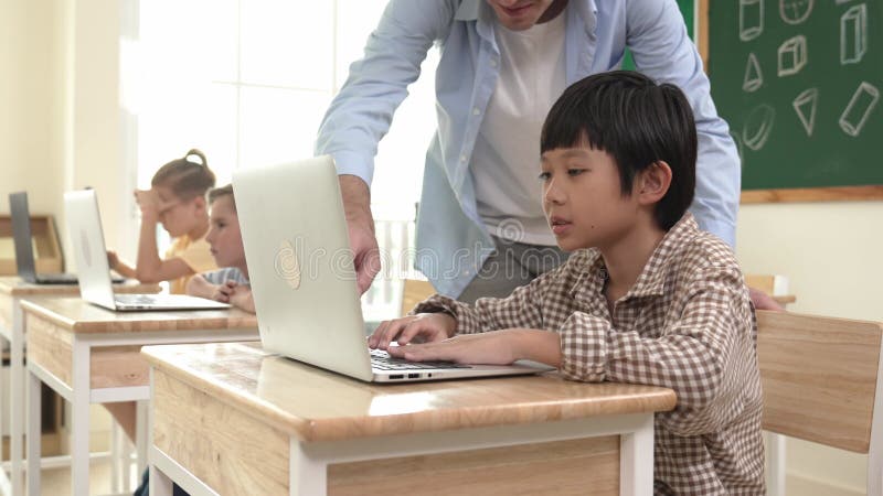 Caucasian teacher helping asian student coding engineering prompt. Pedagogy. stock footage
