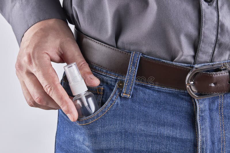 caucasian white male person with hand spray sanitizer at his jeans pocket. self protection at pandemic time