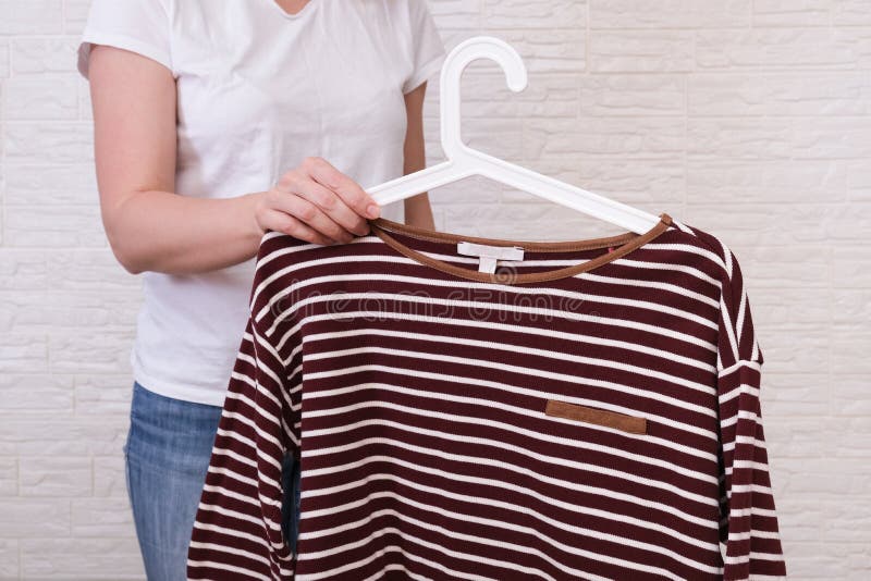 Caucasian Woman Choosing Clothes, she is Holding a Hanger with Striped  Sweatshirt , Shopping, Fitting and Buying Clothes during Stock Image -  Image of caucasian, choosing: 177276629