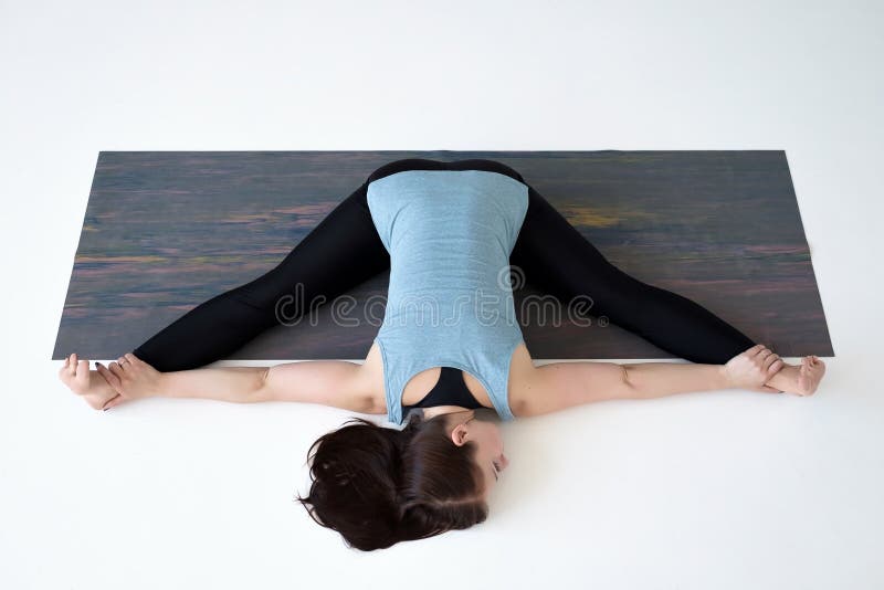 Caucasian woman doing yoga splits upavistha konasana on fitness mat. stock photos Caucasian woman doing yoga splits upavistha konasana on fitness mat. stock photos