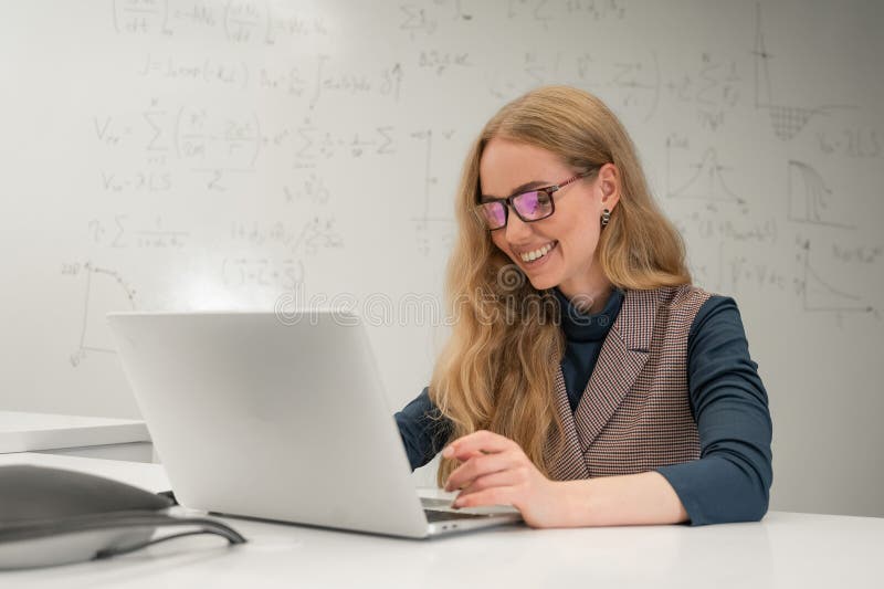 Caucasian woman scientist typing on laptop. White board with formulas. royalty free stock images