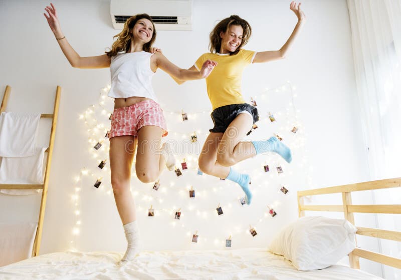 Caucasian Women Jumping on the Bed Together Stock Photo - Image of ...