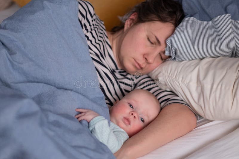 Caucasian Young Mom and Her Cute Little Baby Sleeping in Bed Stock