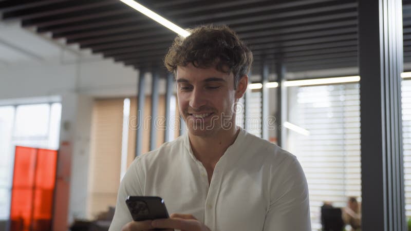 Caucasien sourire positif marche à l'intérieur entreprise homme d'affaires heureux avec téléphone marche au bureau bavardage clips vidéos
