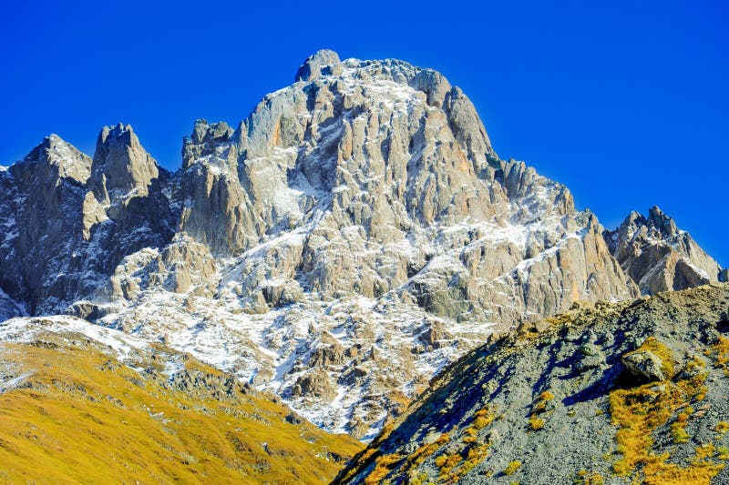 Caucasus mountains in summer, green grass on hills and snow on Chiukhebi peak. village Juta, Georgia