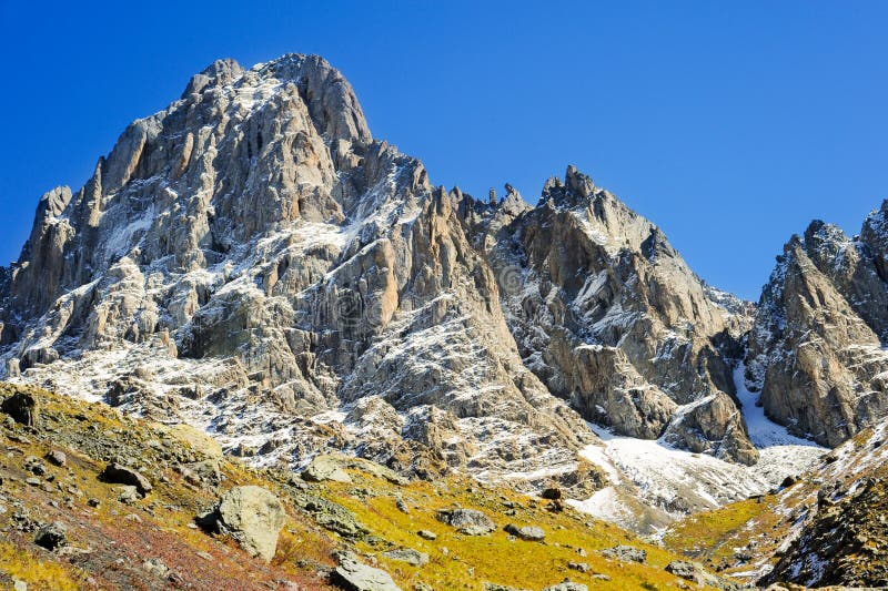 Caucasus Mountains, village Juta. green field and snowy peak Chaukhebi in summer. Georgia