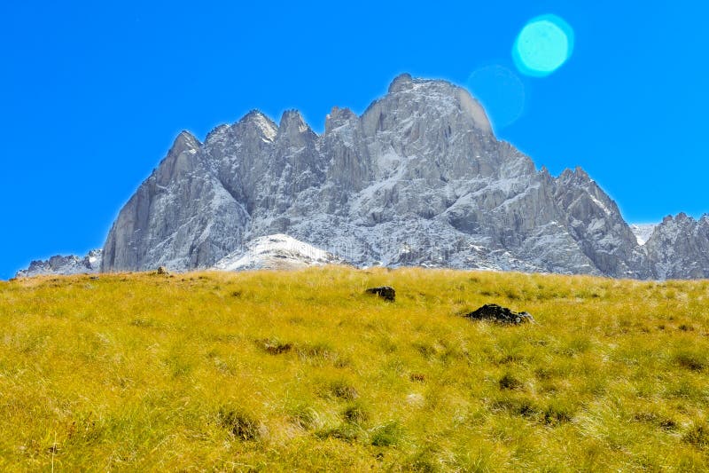 Caucasus Mountains, village Juta. green field and snowy peak Chaukhebi in summer. Georgia