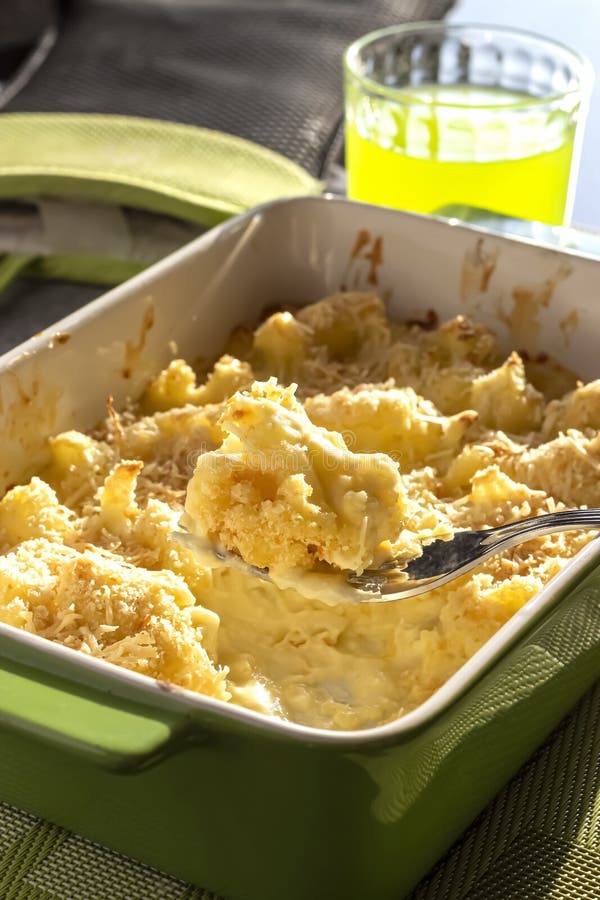 Cauliflower and Cheese Gratin in Green Ceramic Baking Form with Fork. Bright Natural Light Stock
