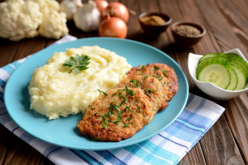 Healthy cauliflower pancakes with mashed potatoes on a wooden background.