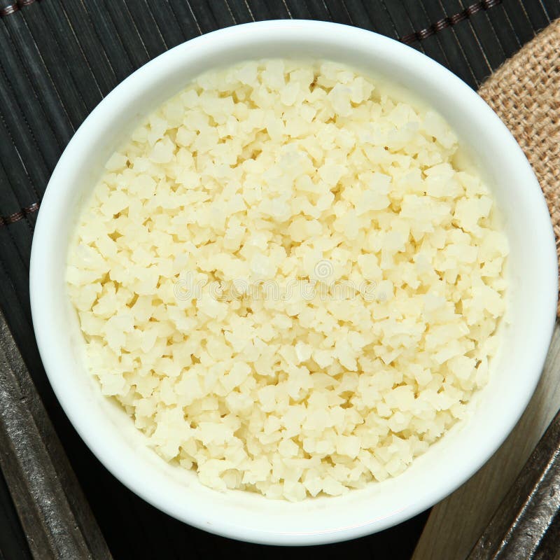 Riced Cauliflower in bowl at table. Paleo cauliflower stock images, royalty-free photos and pictures