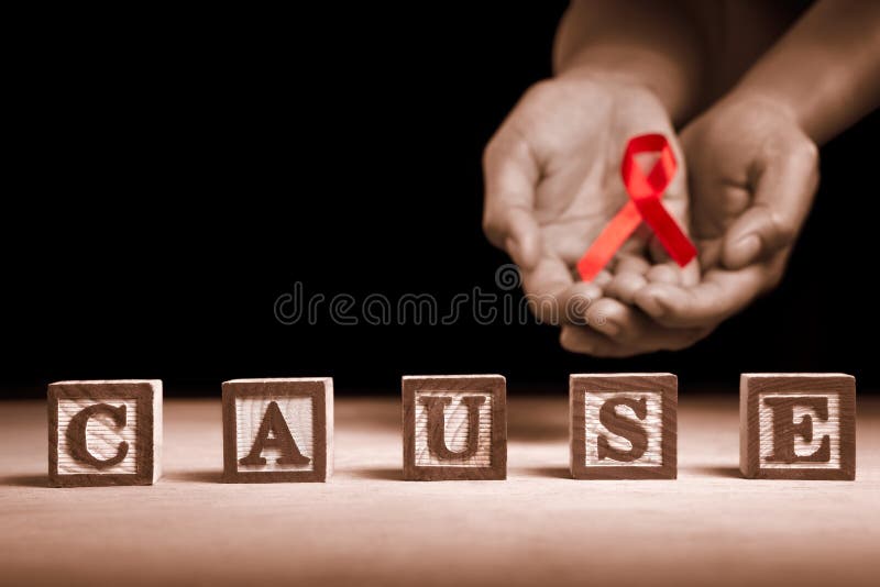 Word 'Cause' from wooden block with hand holding red ribbon on dark background. Word 'Cause' from wooden block with hand holding red ribbon on dark background