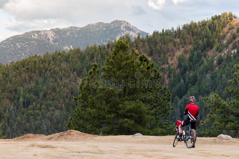 Cavaleiro da bicicleta e Mountain View rochoso foto de stock Cavaleiro da bicicleta e Mountain View rochoso foto de stock