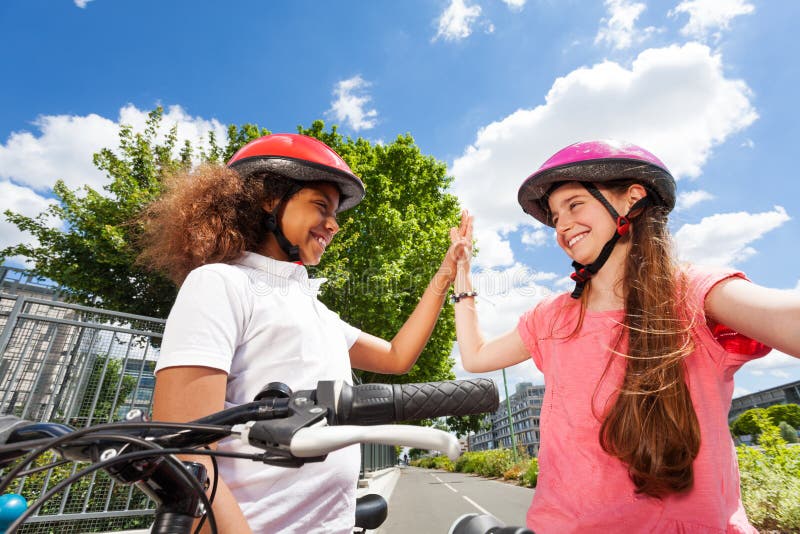 Cavalieri felici della bici che danno livello cinque dopo la corsa immagine stock Cavalieri felici della bici che danno livello cinque dopo la corsa immagine stock