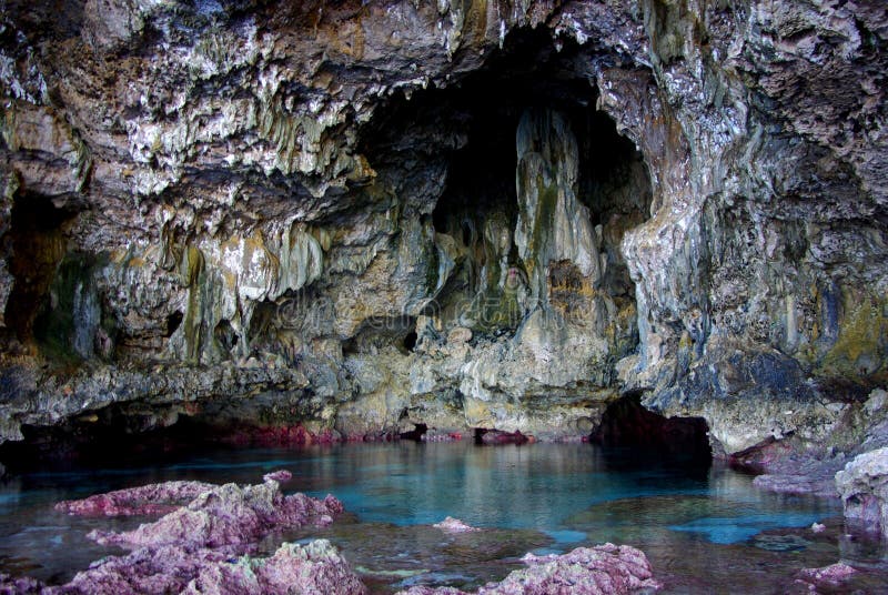 Facing out to the ocean, beautiful Avaiki Cave features limestone stalagtites hanging over a brilliant blue pool filled with delicate corals and tropical fish (Niue). Facing out to the ocean, beautiful Avaiki Cave features limestone stalagtites hanging over a brilliant blue pool filled with delicate corals and tropical fish (Niue).