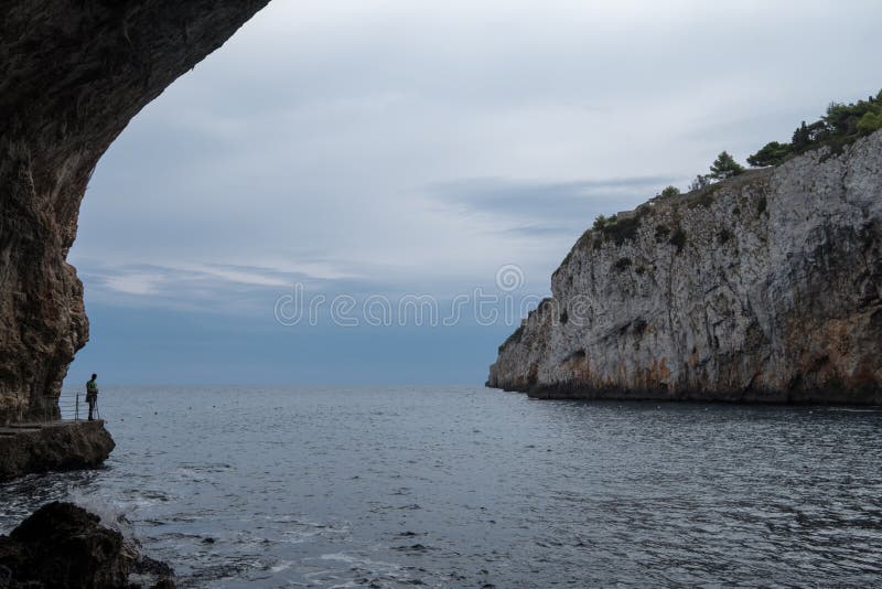 Caves of Zinzulusa, near Castro on the Salento Peninsula in Puglia, Italy. Person in silhouette stands on the gang plank royalty free stock photos Caves of Zinzulusa, near Castro on the Salento Peninsula in Puglia, Italy. Person in silhouette stands on the gang plank royalty free stock photos