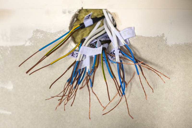 Cavi collegati esposti elettrici che sporgono dall'incavo sulla parete bianca Installazione elettrica dei collegamenti Impianti d fotografia stock libera da diritti Cavi collegati esposti elettrici che sporgono dall'incavo sulla parete bianca Installazione elettrica dei collegamenti Impianti d fotografia stock libera da diritti