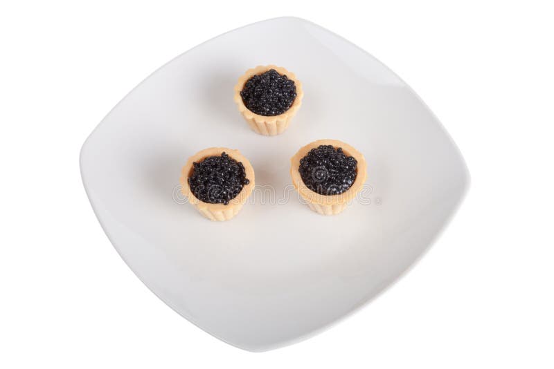 Caviale nero in tortini sul piatto bianco, isolato su backg bianco immagine stock libera da diritti Caviale nero in tortini sul piatto bianco, isolato su backg bianco immagine stock libera da diritti