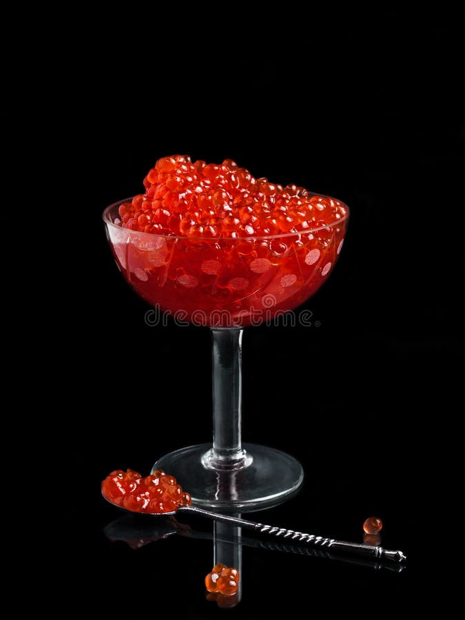 Caviar roșu într-o vază de sticlă pe fond negru cu ref stock images
