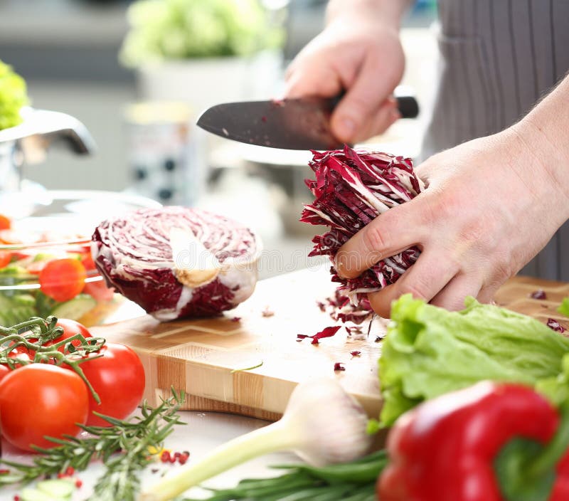 Cavolo porpora di Holding Sliced Chopped del cuoco unico maschio fotografia stock Cavolo porpora di Holding Sliced Chopped del cuoco unico maschio fotografia stock