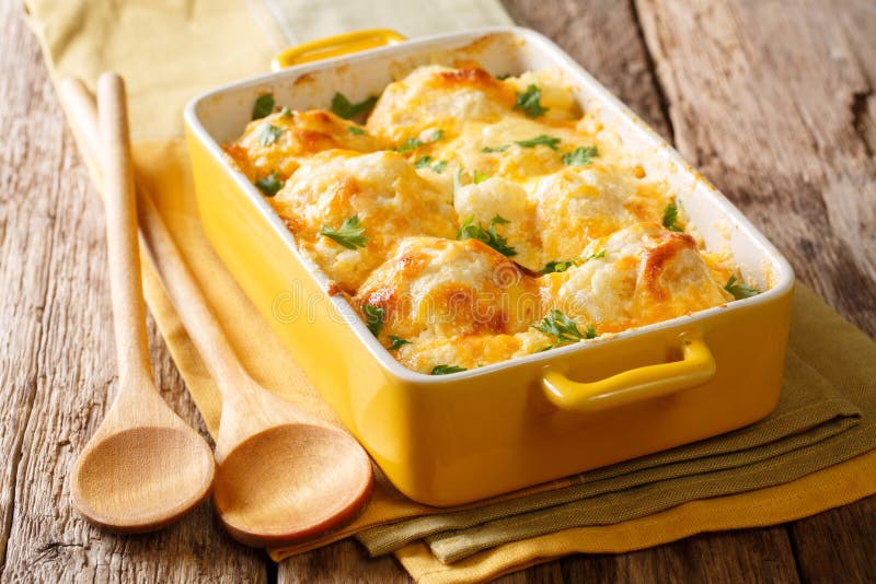 Casserole from cauliflower with bechamel sauce close-up in a baking dish on a table. horizontal. Casserole from cauliflower with bechamel sauce close-up in a baking dish on a table. horizontal