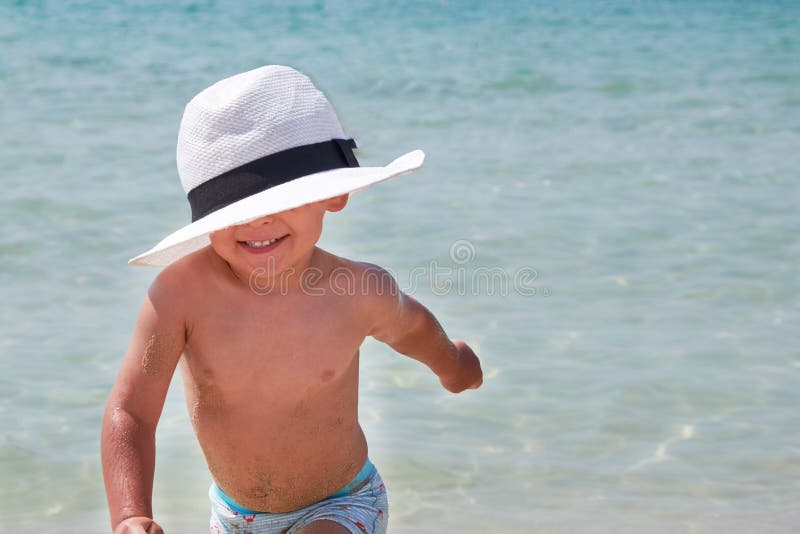 Caçoa o estilo de vida exterior Menino bonito feliz em Panamá que joga com a areia na praia do mar Férias e família de verão foto de stock Caçoa o estilo de vida exterior Menino bonito feliz em Panamá que joga com a areia na praia do mar Férias e família de verão foto de stock