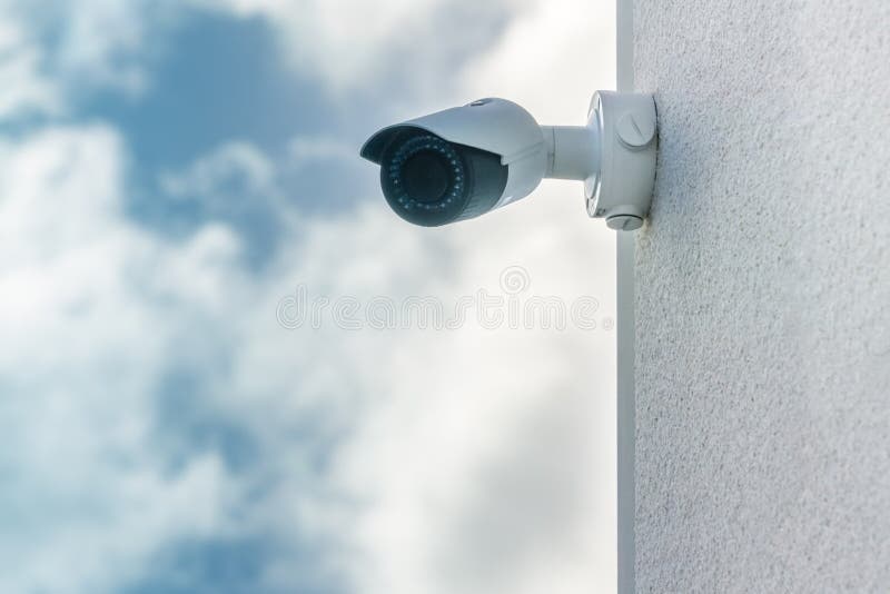 Cctv-Überwachungskamera im vorderen Hintergrund des blauen Himmels installiert auf weiße errichtende Wand stockbild Cctv-Überwachungskamera im vorderen Hintergrund des blauen Himmels installiert auf weiße errichtende Wand stockbild