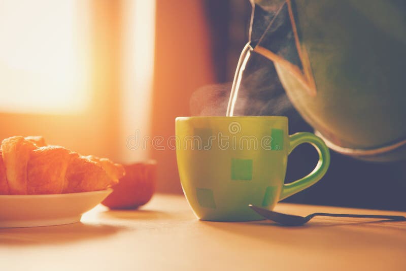 Ceainic turnând apă fiartă în cupă stock photo