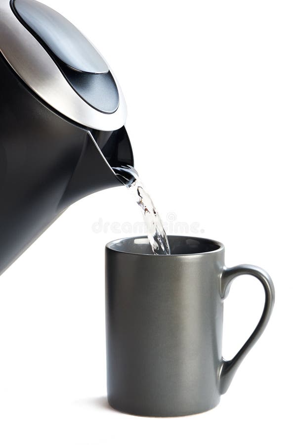 Ceainicul modern care toarnă apă în cupă izolată pe alb stock images
