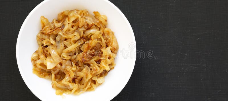 Ceapă caramelizată artizanală pe o placă albă pe o vedere de fond neagră. de deasupra întinderii plane de acoperire. spațiu pentru stock photography