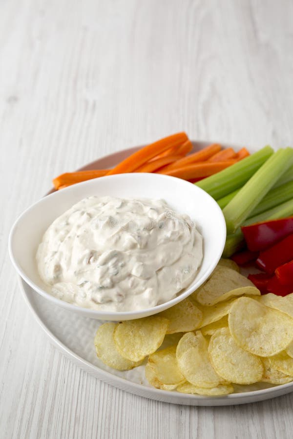 Ceapă caramelizată de uz casnic, cu chipsuri de cartofi, piper de țelină și morcov pe un fond alb din lemn, cu unghi scăzut. copie stock photos