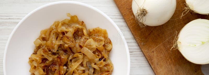 Ceapă caramelizată de uz casnic pe o placă albă, pe o vedere superioară, din lemn, albă. cheltuieli de regie fixe de deasupra. înc stock image