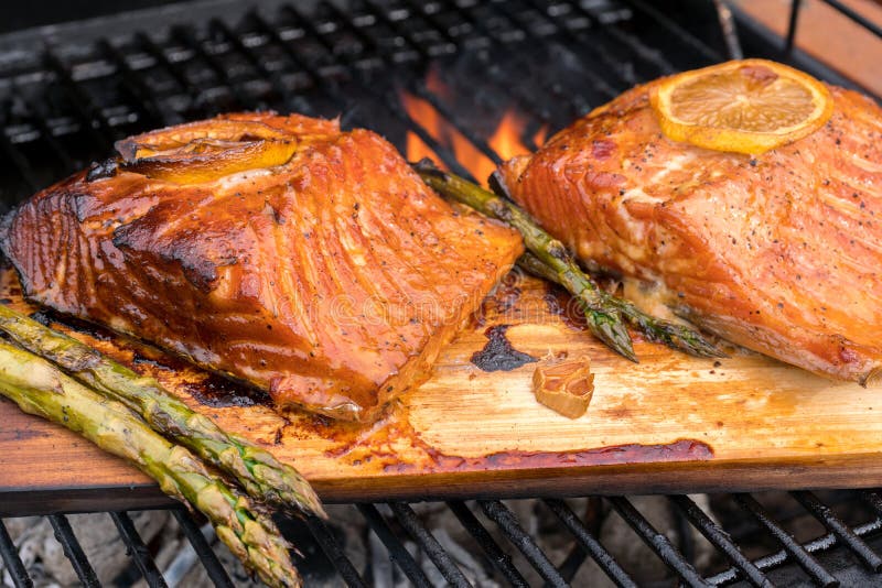 Cedar plank salmon with lemon on a grill