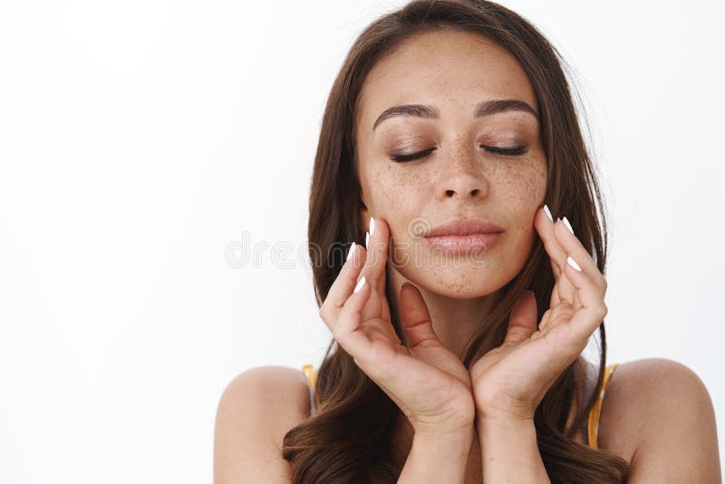Cefalea tierna y mujer femenina hermosa bronceada con pecas y cabello oscuro, tacto de piel limpia suavemente, masaje imagen de archivo