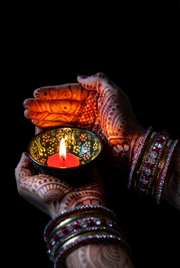 Woman hands with henna holding lit candle isolated on black background with clipping path. Woman hands with henna holding lit candle isolated on black background with clipping path