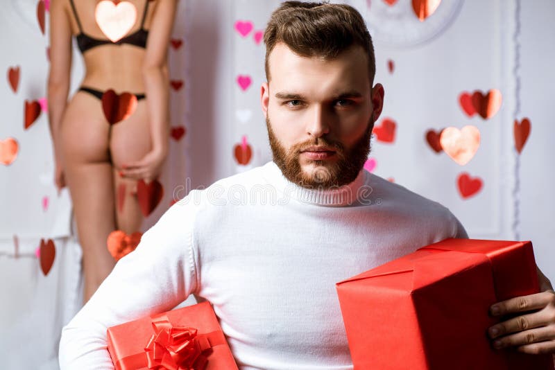 Celebrate love. Romantic surprise. Valentines day gift. Gift for girlfriend. Attractive macho with gifts celebrate stock image Celebrate love. Romantic surprise. Valentines day gift. Gift for girlfriend. Attractive macho with gifts celebrate stock image