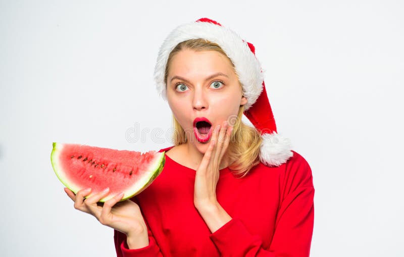 Celebri l'estate del nuovo anno La ragazza di Natale mangia l'anguria Il cappello di Santa di usura della ragazza mangia il fondo fotografia stock libera da diritti Celebri l'estate del nuovo anno La ragazza di Natale mangia l'anguria Il cappello di Santa di usura della ragazza mangia il fondo fotografia stock libera da diritti