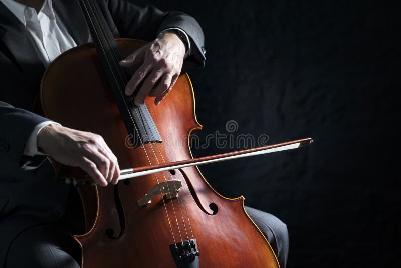 Cello player of cellist die op orkestachtergrond optreedt