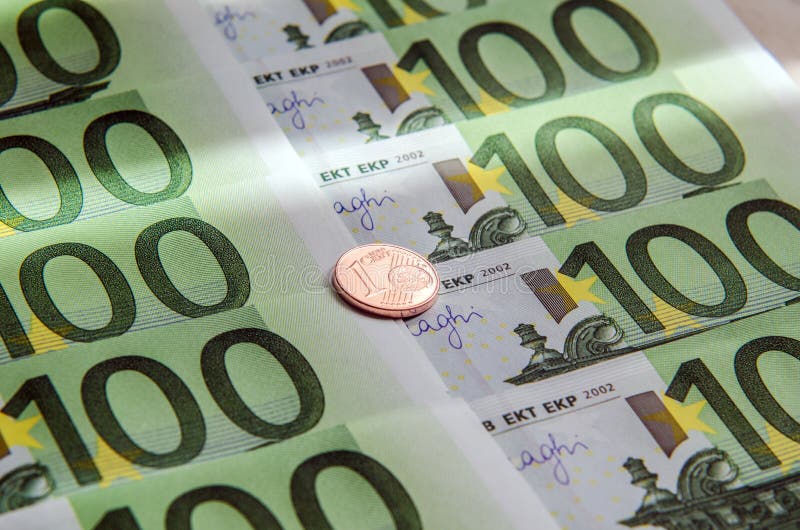 Cem cédulas do Euro e moedas de um centavo imagem de stock Cem cédulas do Euro e moedas de um centavo imagem de stock