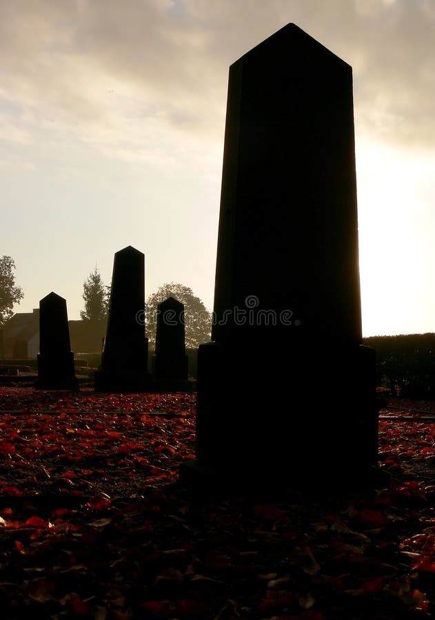 Graveyard in november with red maple leaves on the ground. Graveyard in november with red maple leaves on the ground