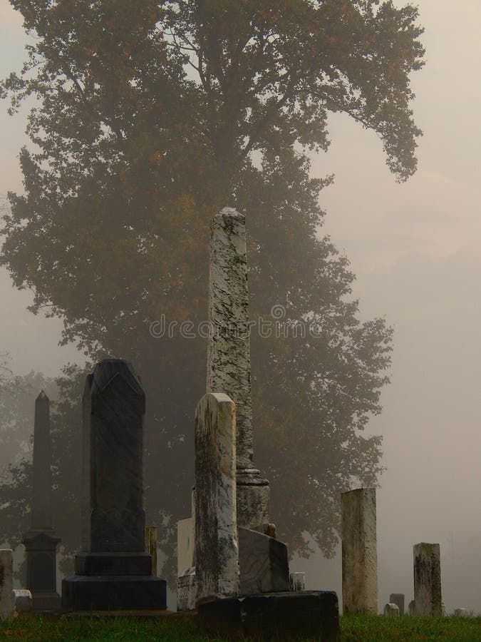 A cold & rainy autumn afternoon in an old graveyard as fog starts to settle in at dusk, leaving the colorful fall foliage barely visible. A cold & rainy autumn afternoon in an old graveyard as fog starts to settle in at dusk, leaving the colorful fall foliage barely visible.